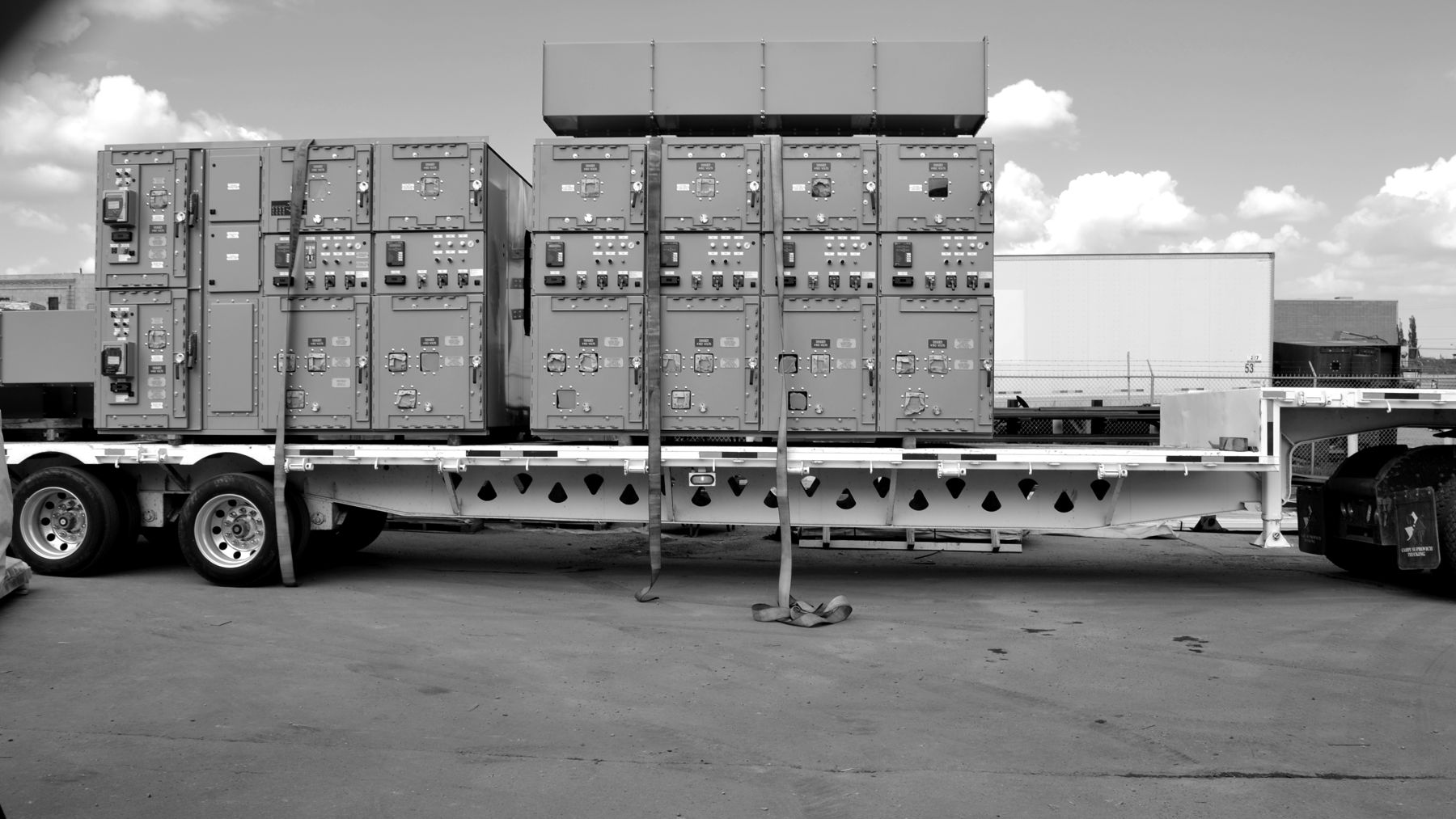Two metal-clad switchgear sections strapped to a flatbed trailer for shipment